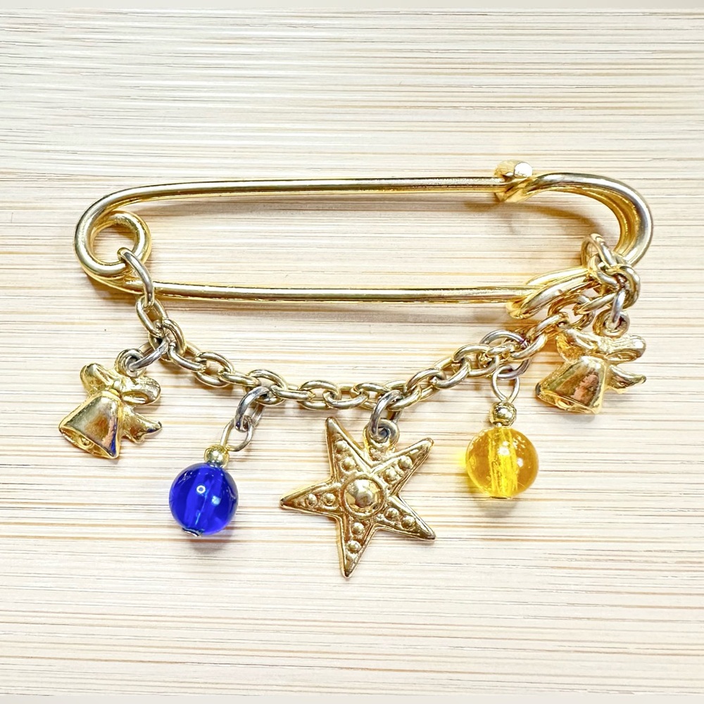 VINTAGE GOLD TONE SAFETY PIN BROOCH WITH CHARMS AND BEADS
